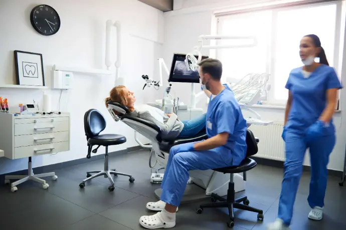 Dentist assisting a patient with dental treatment exercises in a clinic