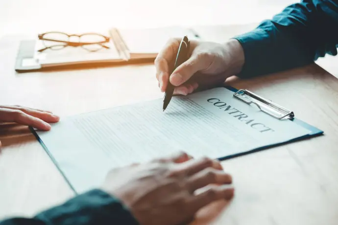 Close-up of two professionals discussing legal documents at a desk