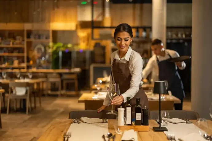 Restaurant waitress prepares a table